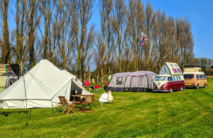 Liilyroo's camp site showing a bell tent with outside table & chairs and two VW camper vans