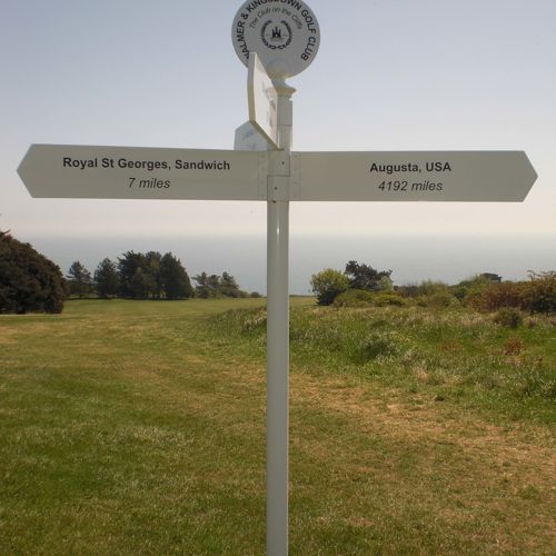 A white signpost to Royal St George's at Sandwich and Augusta, USA on the golf course at Walmer and Kingsdown Golf Club.