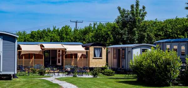 A group of shepherd's huts on a lawn.