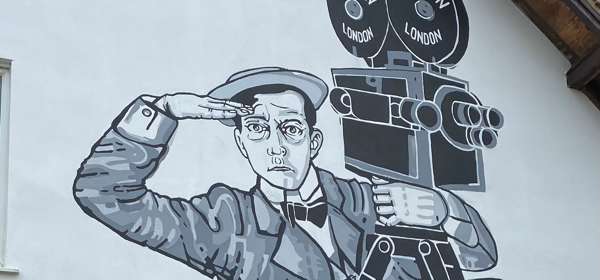 Black and white mural of Buster Keaton on side of a building