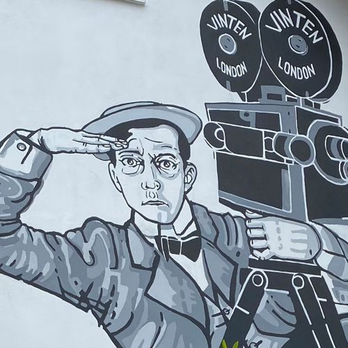 Black and white mural of Buster Keaton on side of a building