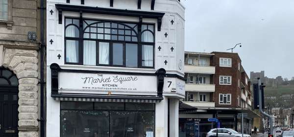 Black and white exterior of Market Square Kitchen in Dover with the castle in the background