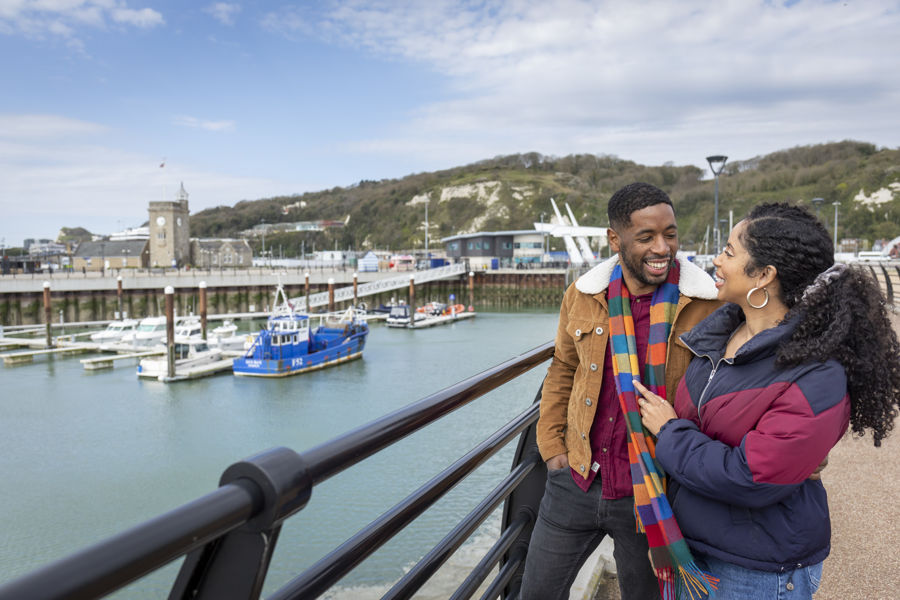 Two people on Dover Pier overlooking Dover Marina.