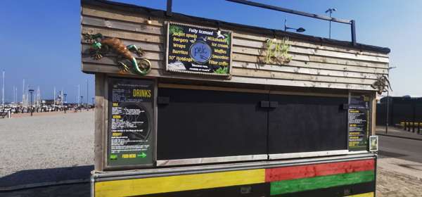 Wooden street food cabin with chalkboard menu.