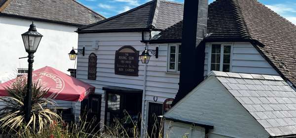 Exterior whitewashed boards of The Rising Sun pub