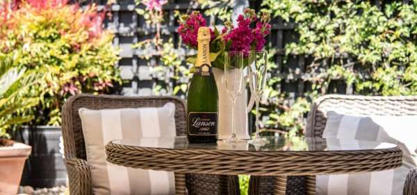 Garden table with two chairs, champagne and two glasses.