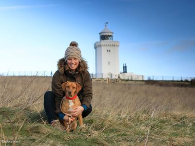 A woman and her dog in front of the South Foreland Lighthouse