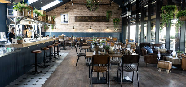 Interior of restaurant showing vaulted ceiling, bar area and seating areas.