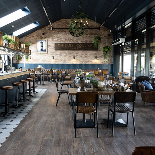 Interior of restaurant showing vaulted ceiling, bar area and seating areas.