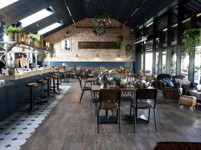 Interior of restaurant showing vaulted ceiling, bar area and seating areas.