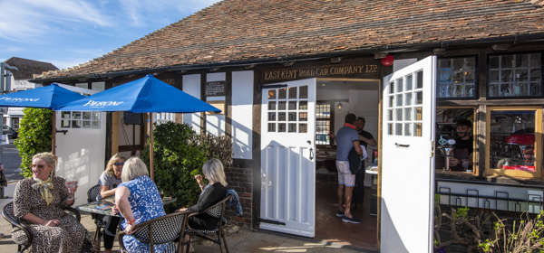 Old bus waiting room building converted to a bar with tables and chairs outside