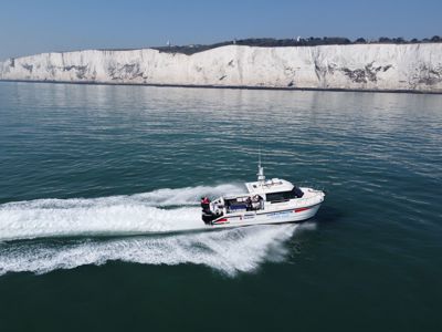 The Wetwheels South East boat speeding across a calm sea with the White Cliffs in the distance.