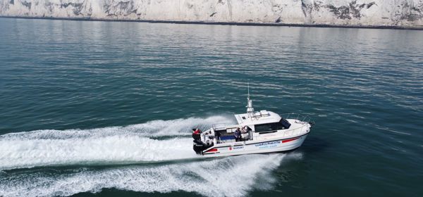 The Wetwheels South East boat speeding across a calm sea with the White Cliffs in the distance.